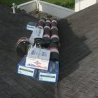 Roofing supplies resting on a shingle roof