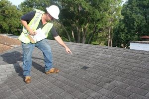 ANC roofer pointing out damages to a shingle rooftop